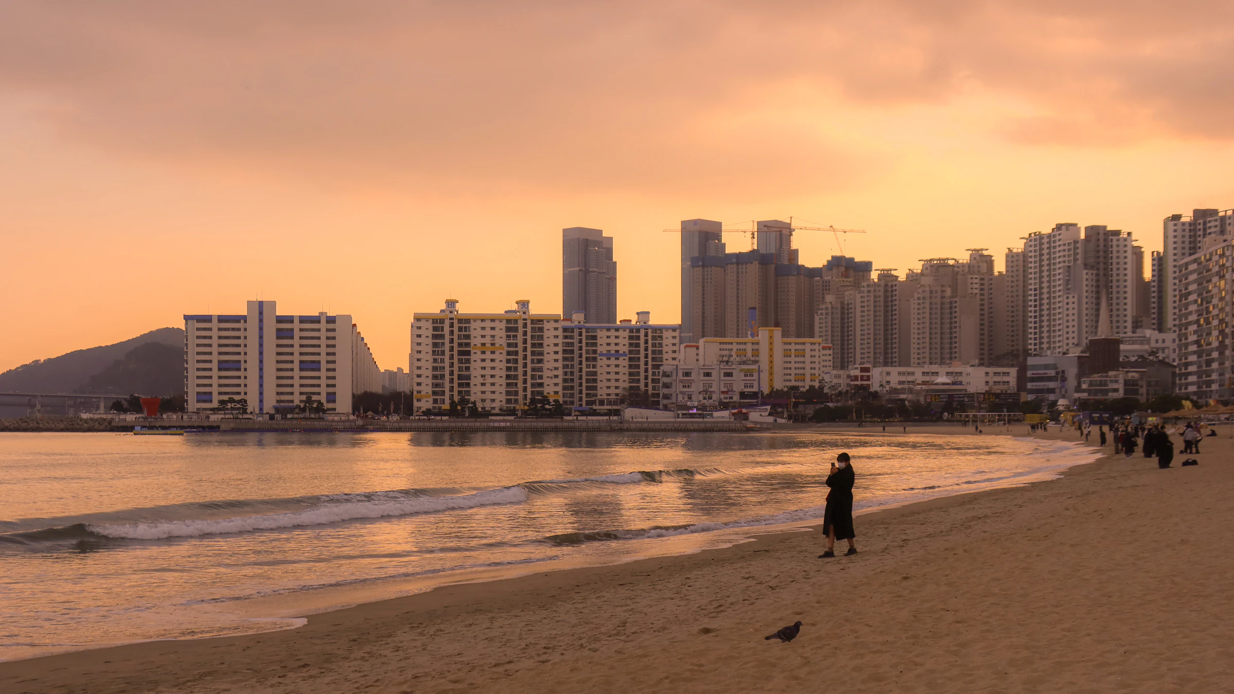 Haeundae Beach in Busan at sunset, the beach curving in front of a wall of high rise apartment towers