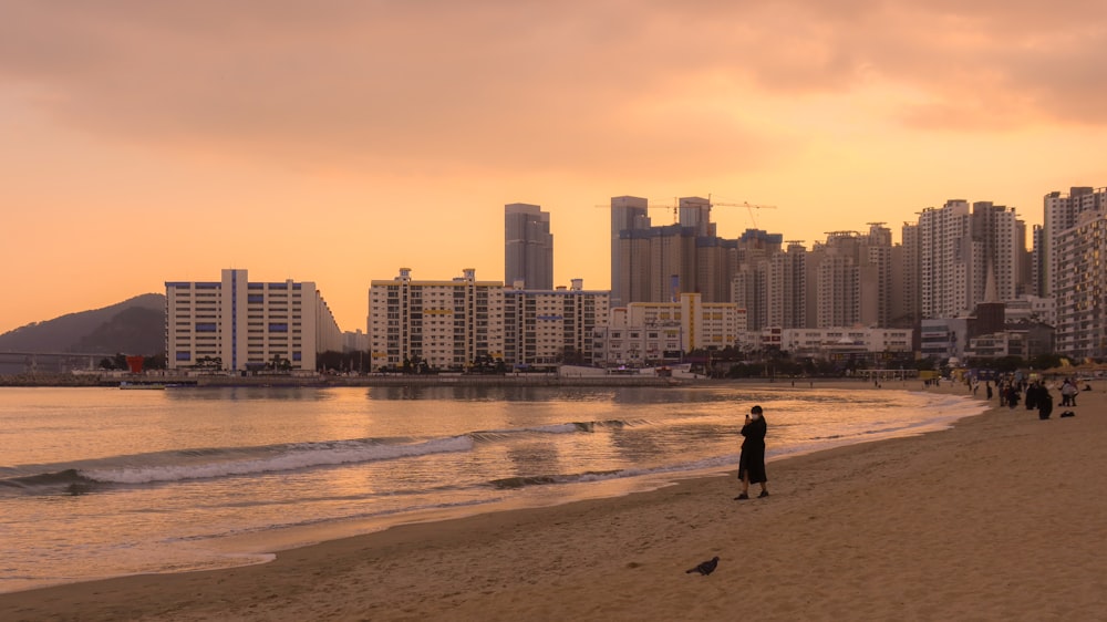 a group of people standing on top of a sandy beach