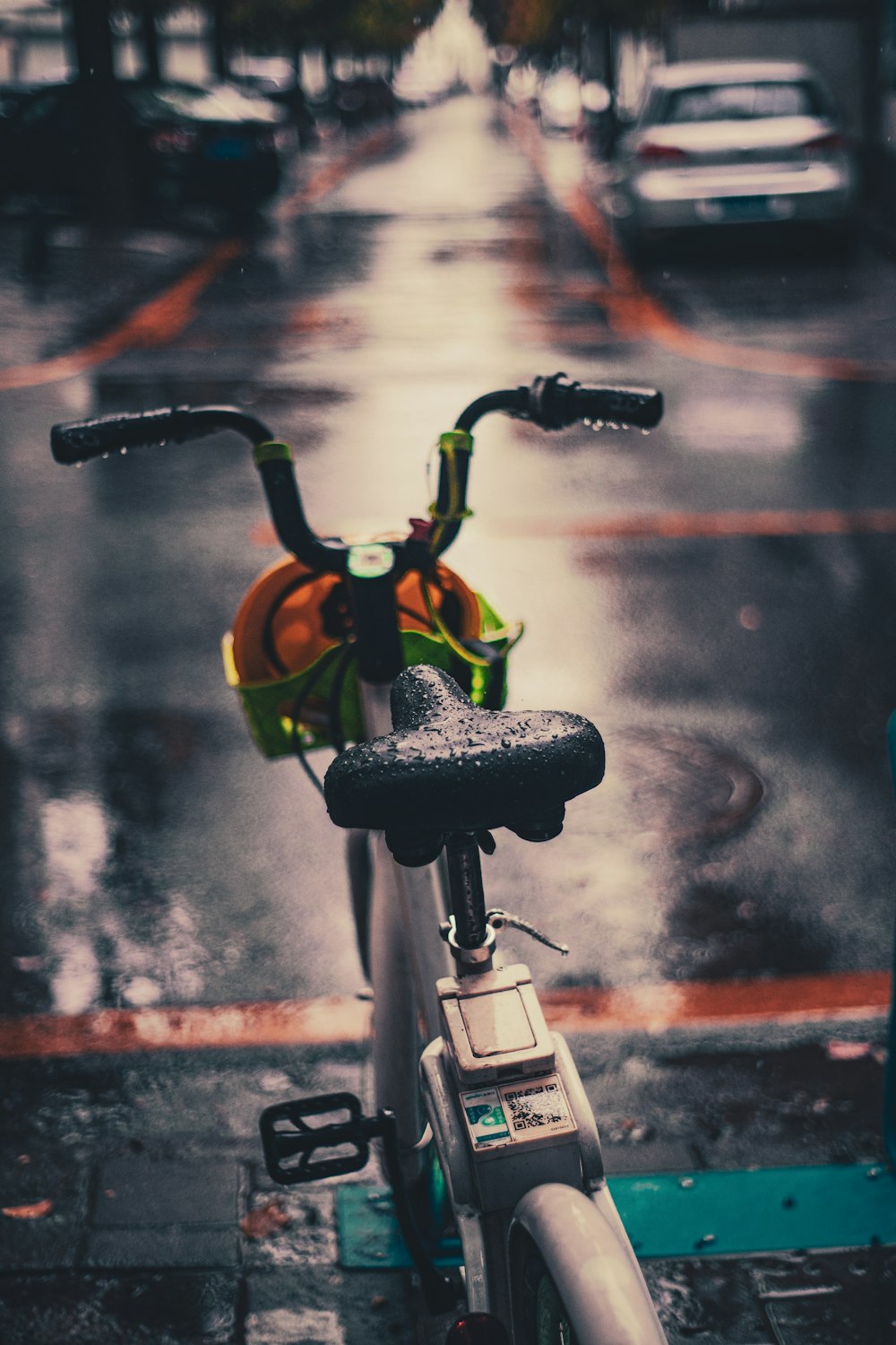 a bicycle parked on the side of the road in the rain