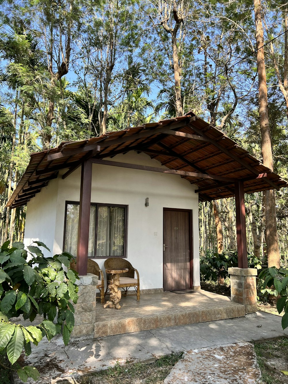 uma pequena casa branca com um telhado de madeira