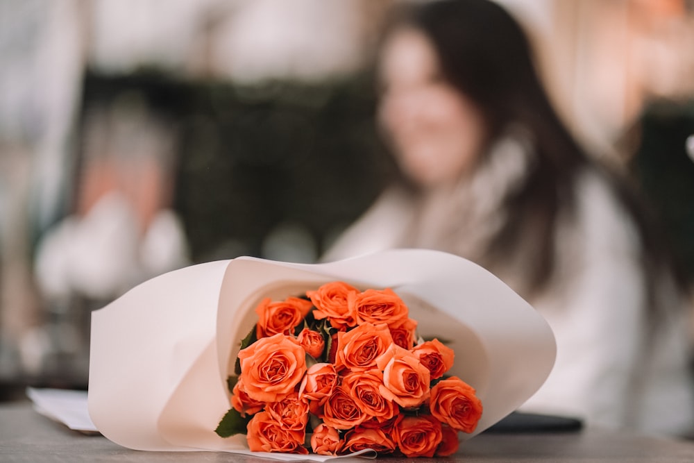 테이블에 앉아 오렌지 장미 꽃다발