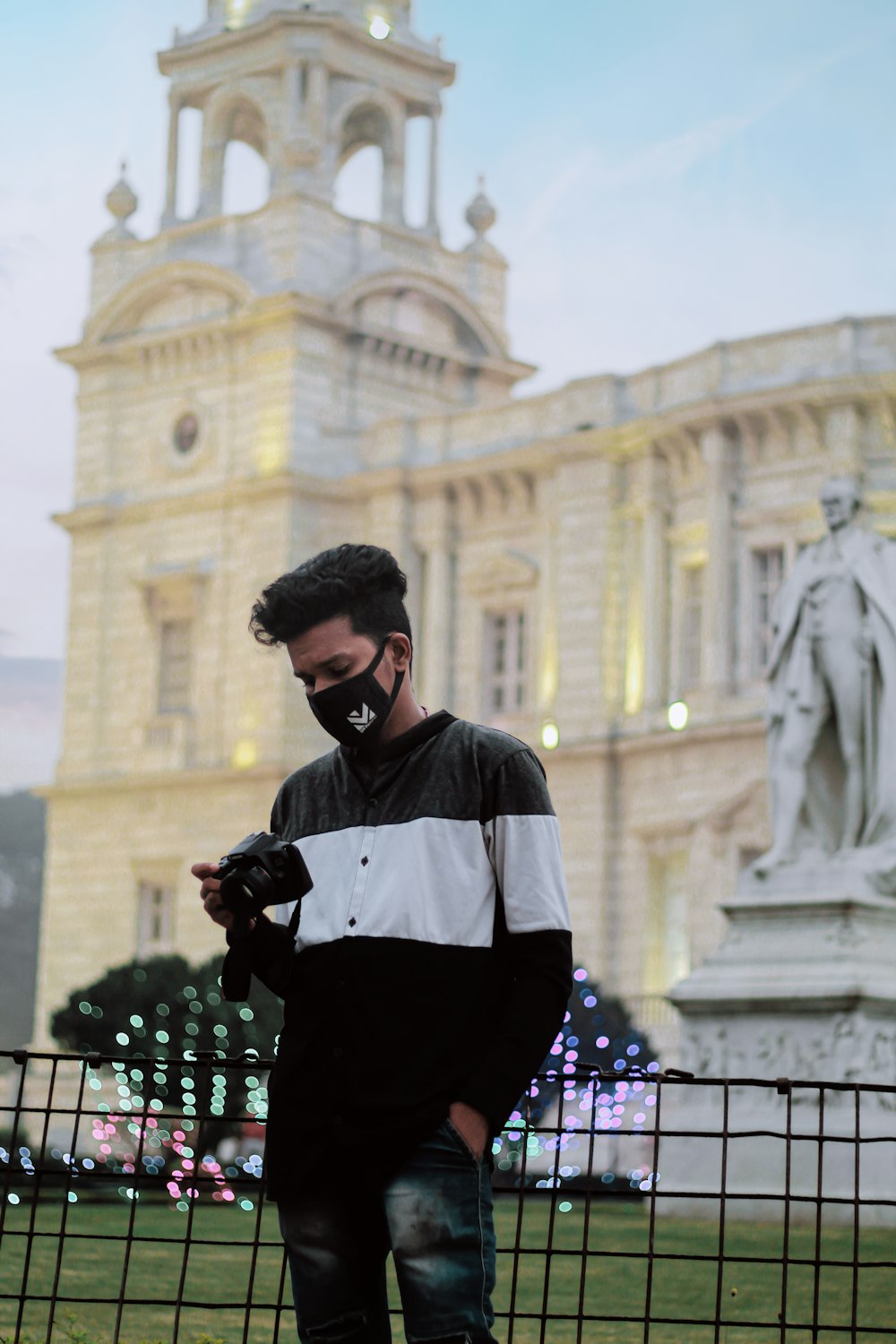 a man standing in front of a building looking at his cell phone