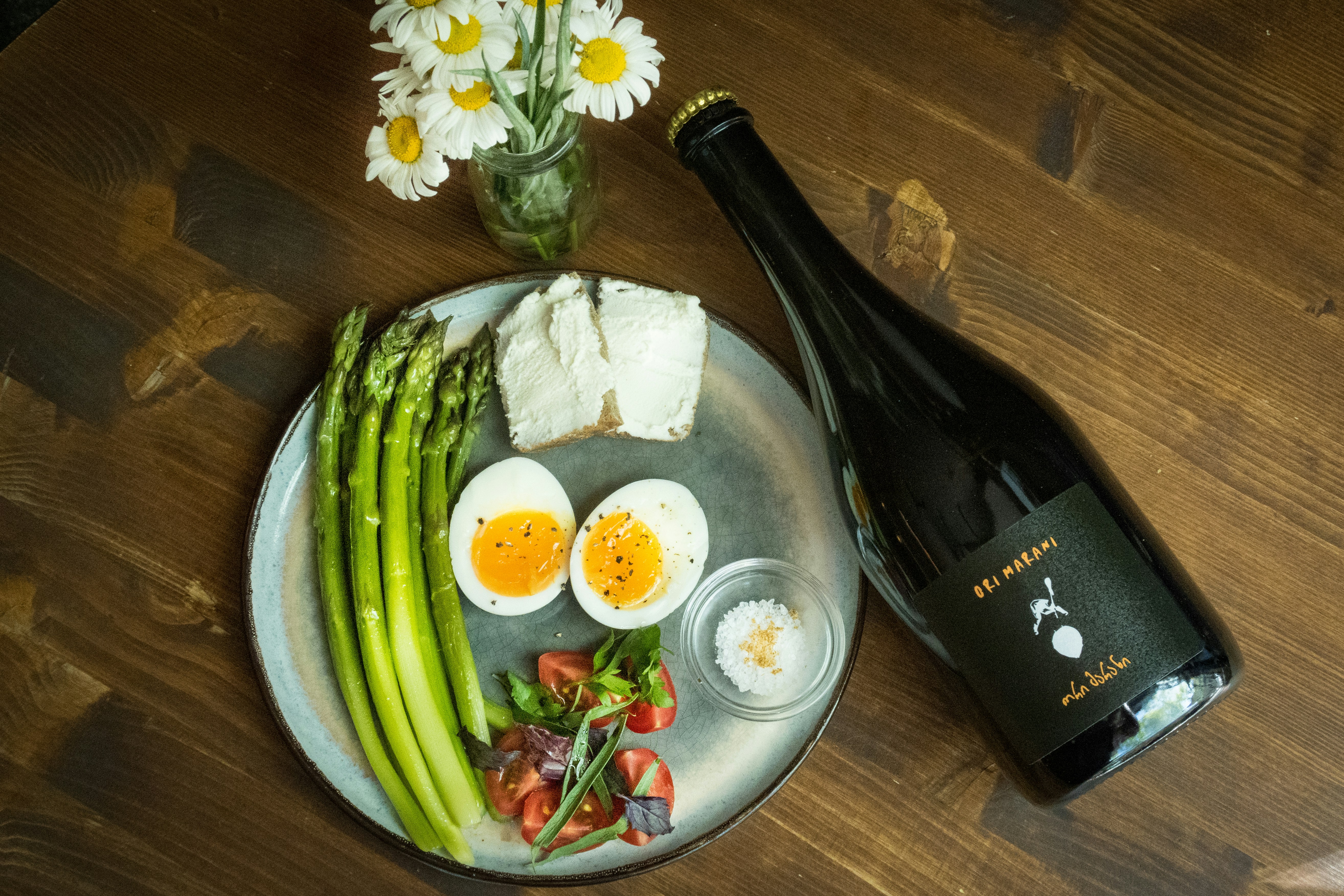 a plate of food and a bottle of wine on a table