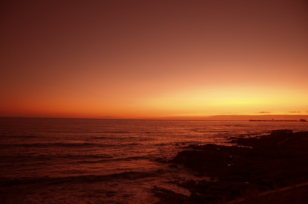 the sun is setting over the ocean on a clear day