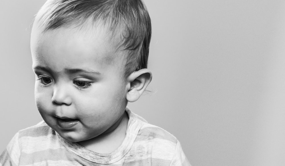 a black and white photo of a toddler making a funny face