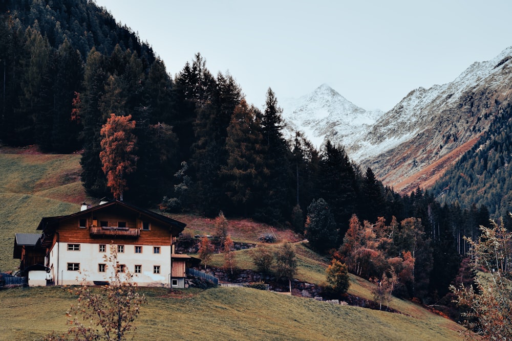 a house on a hill with mountains in the background