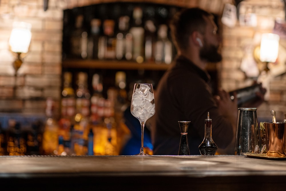 a man sitting at a bar with a drink in front of him