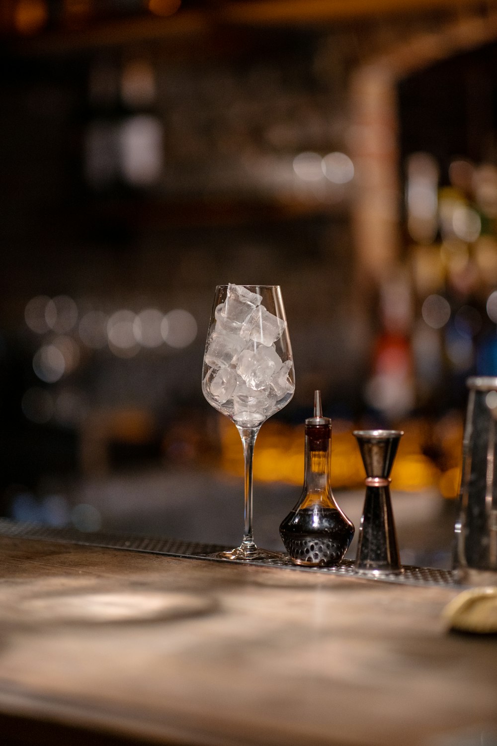 a glass of ice and a salt shaker on a bar