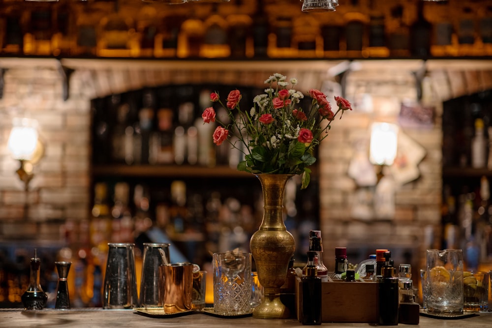 a table with a vase of flowers and glasses on it