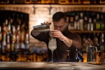 a man is making a drink at a bar