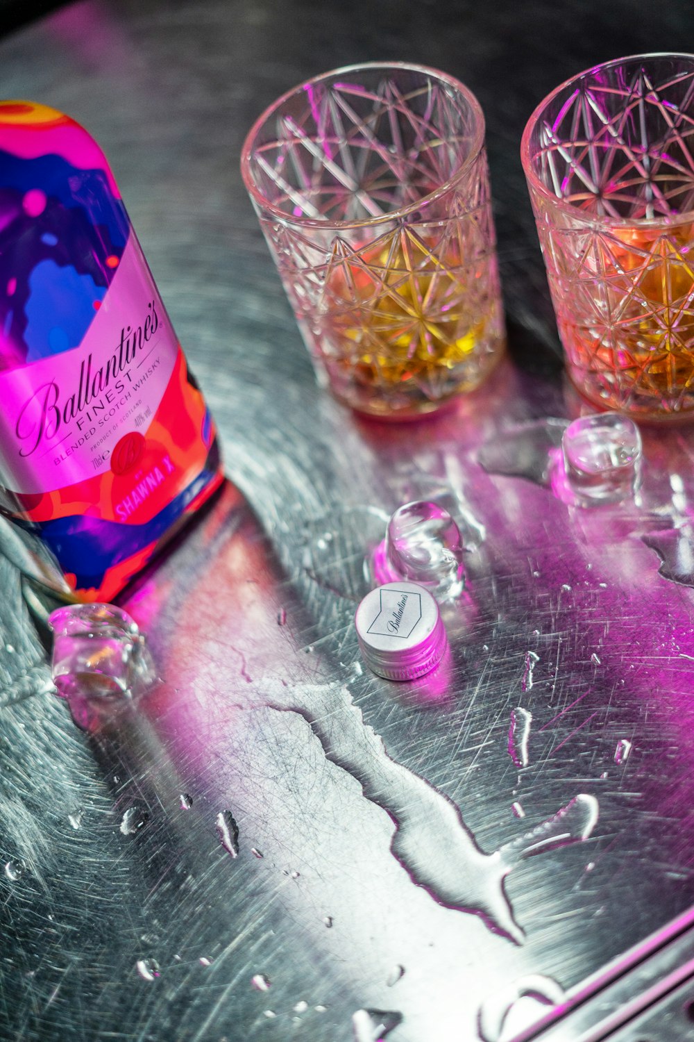 a bottle and two glasses sitting on a table