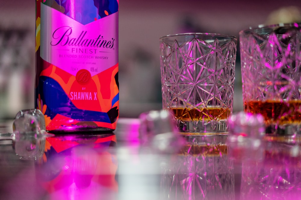 a bottle of ballantines finest sitting next to a glass