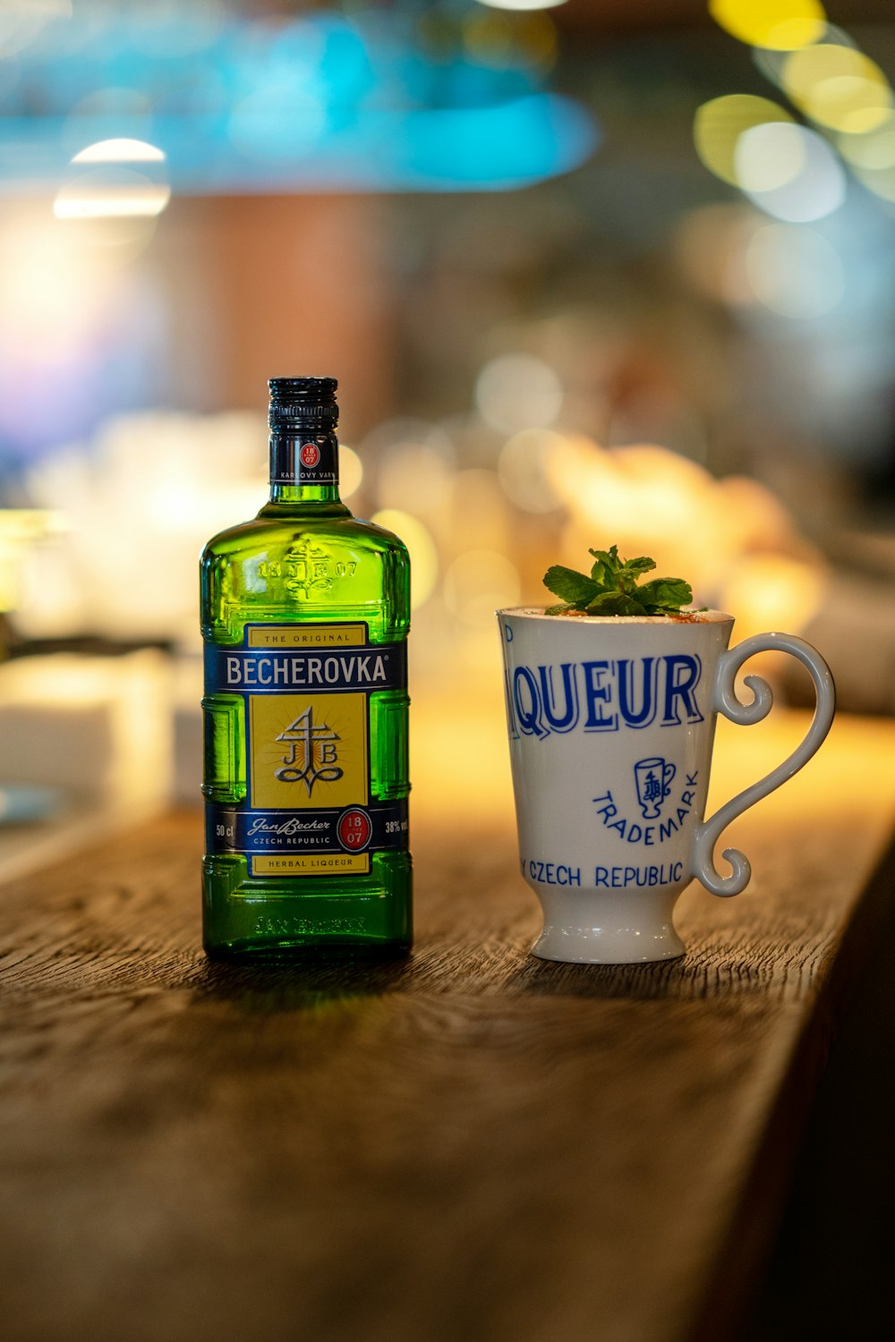 a bottle of liquor and a cup on a table