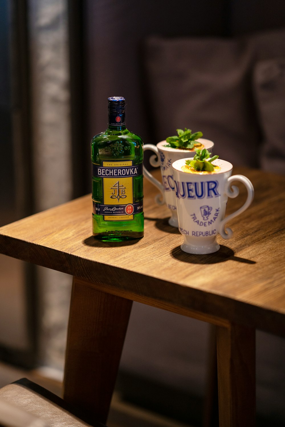 a table with a bottle of alcohol and a bowl of food on it