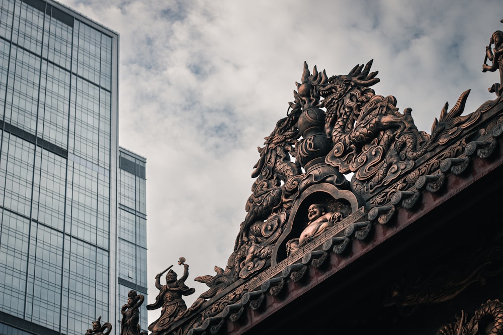 a building with a statue on top of it next to a tall building