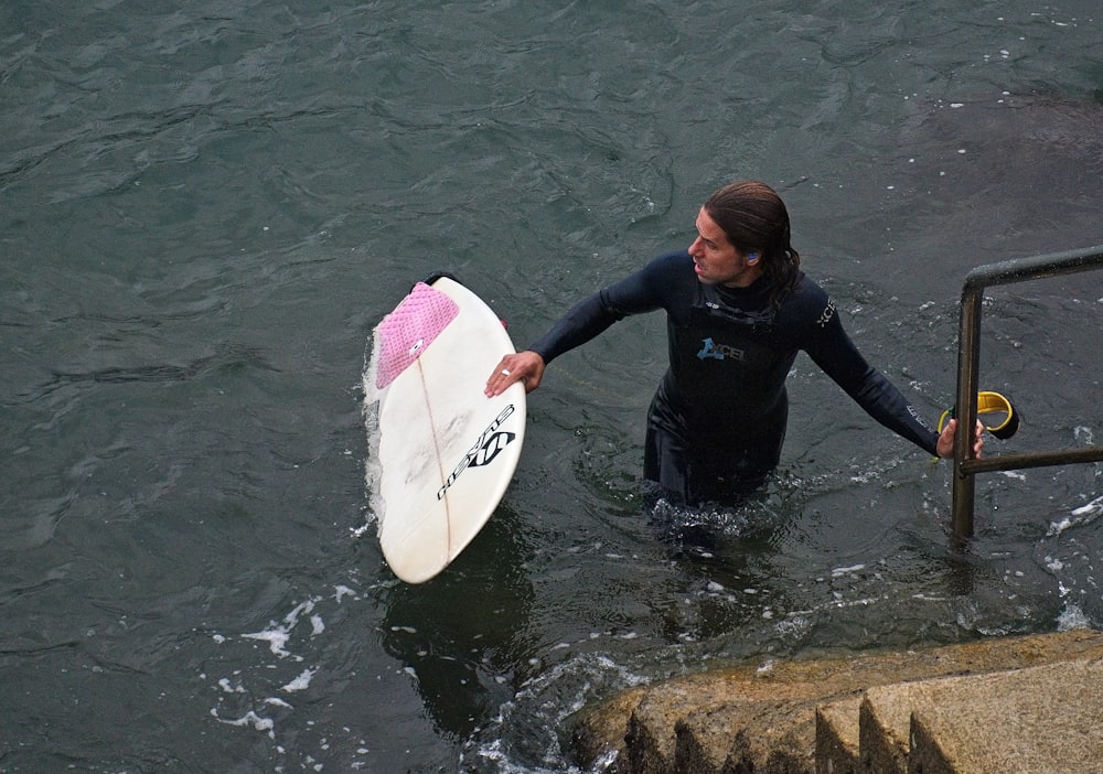 a man wearing a wet suit riding a surf board in the water