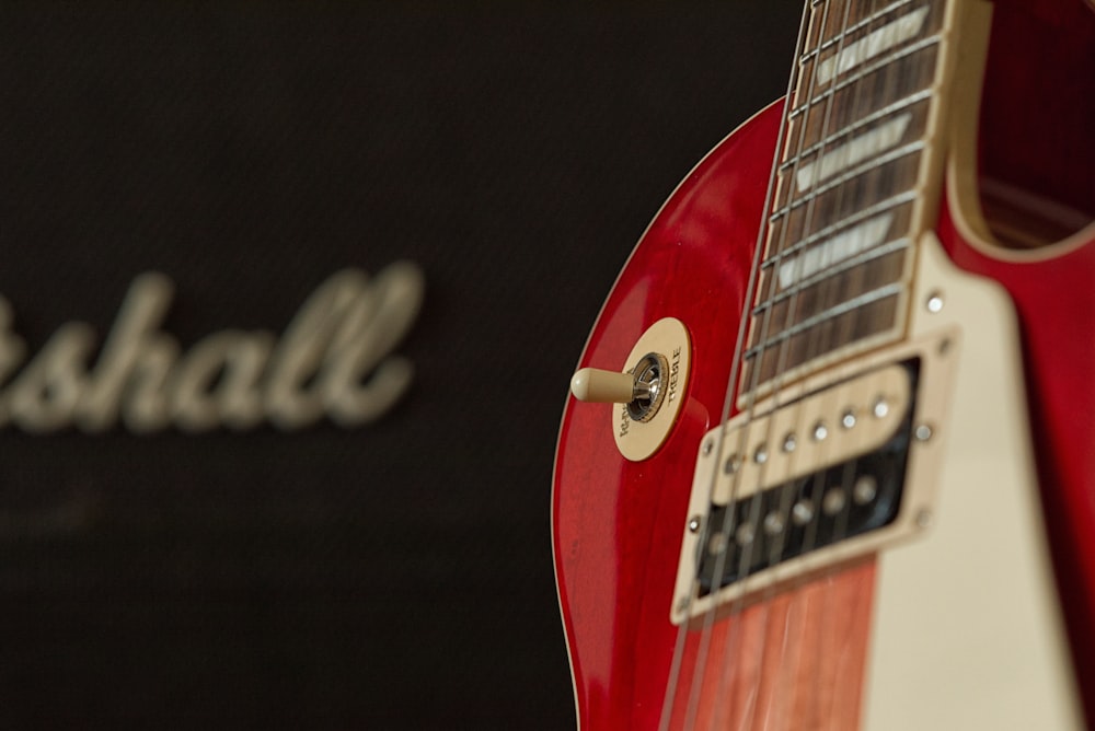 a close up of a red and white guitar