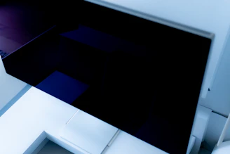 A sleek digital architectural model displayed on a high-resolution screen in a modern studio.