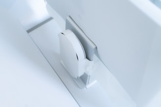 A sleek, modern display of neatly arranged electronics on a minimalist white shelf.