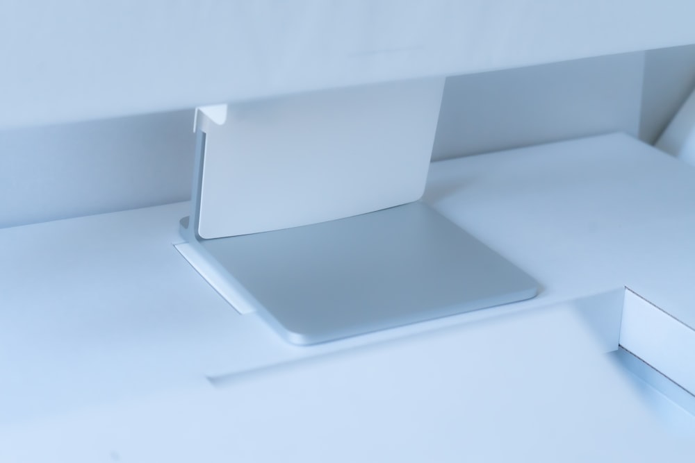 um monitor de computador sentado em cima de uma mesa branca