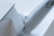 A close-up view of a modern, minimalist white object with sharp edges and geometric shapes. The design is sleek and clean with a focus on angular forms and subtle details.