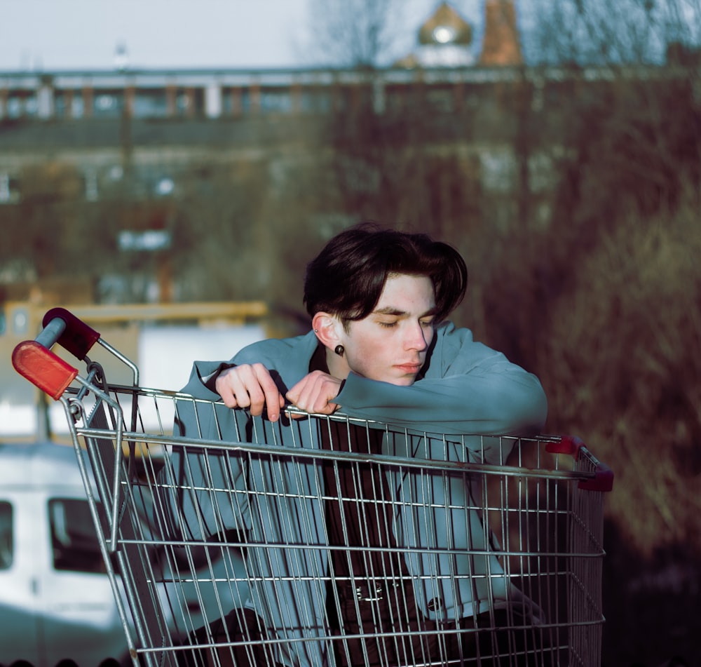 a woman leaning on top of a shopping cart