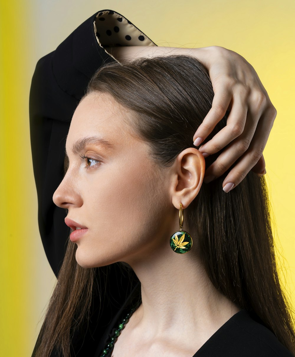 a woman putting a pair of earrings on her head