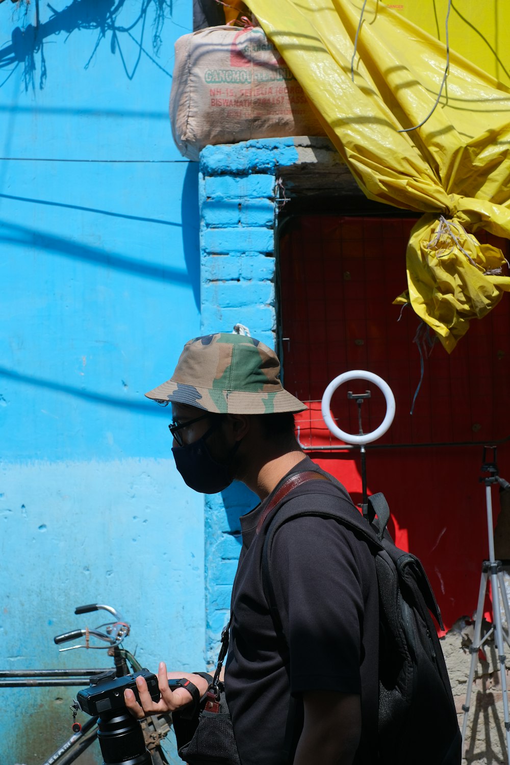 a man wearing a face mask and carrying a bicycle