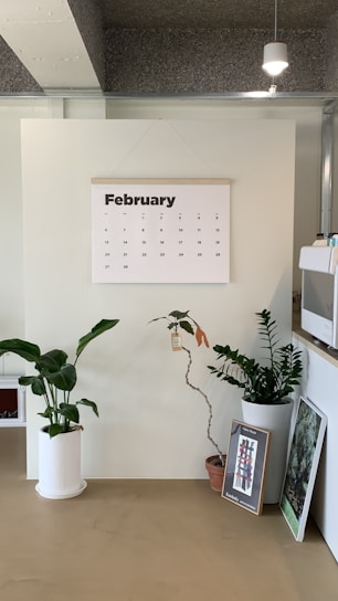 a desk with a calendar and plants on it