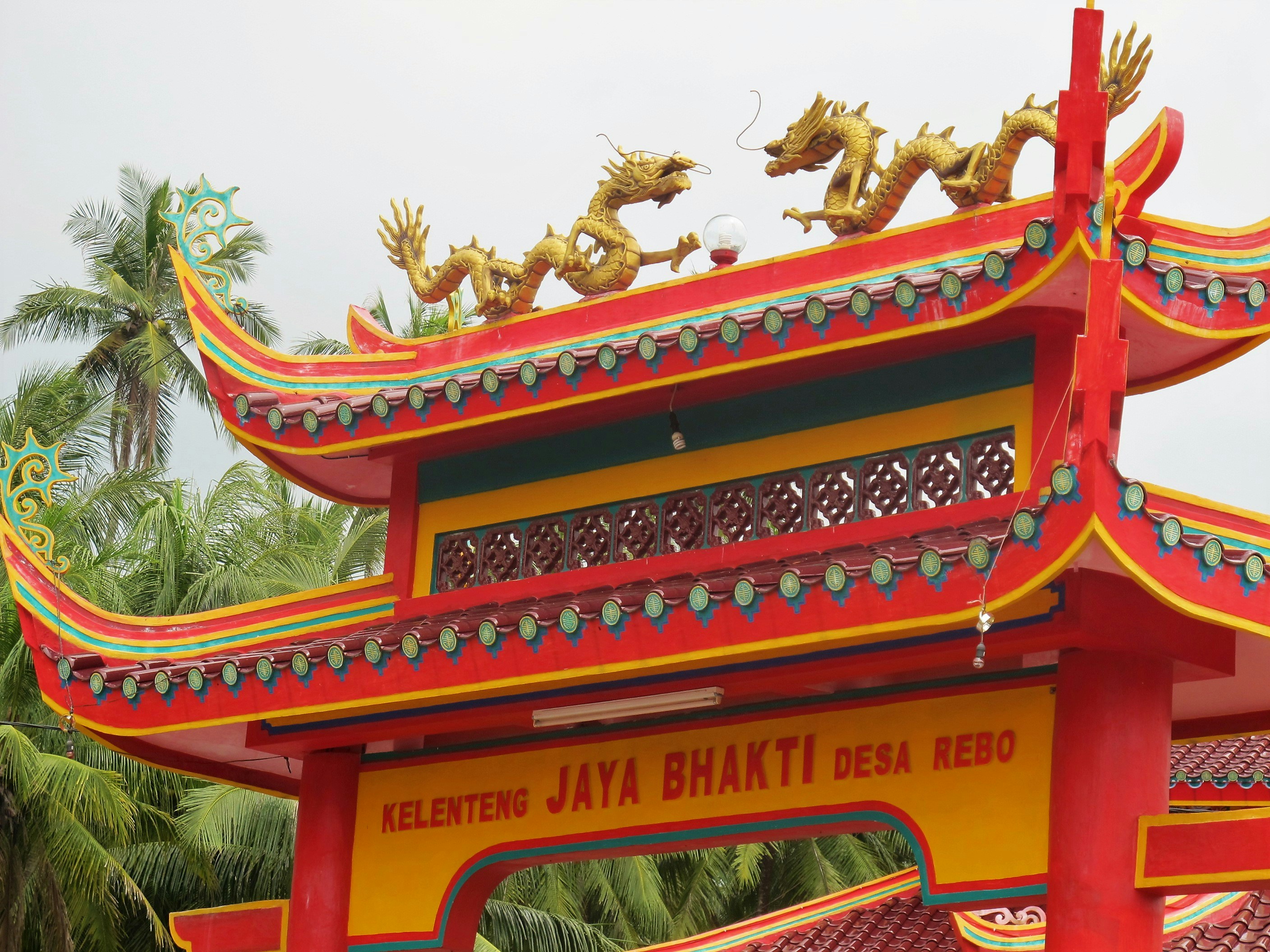 龍の像を頂上にした赤と黄色の建物の写真 – Unsplashの