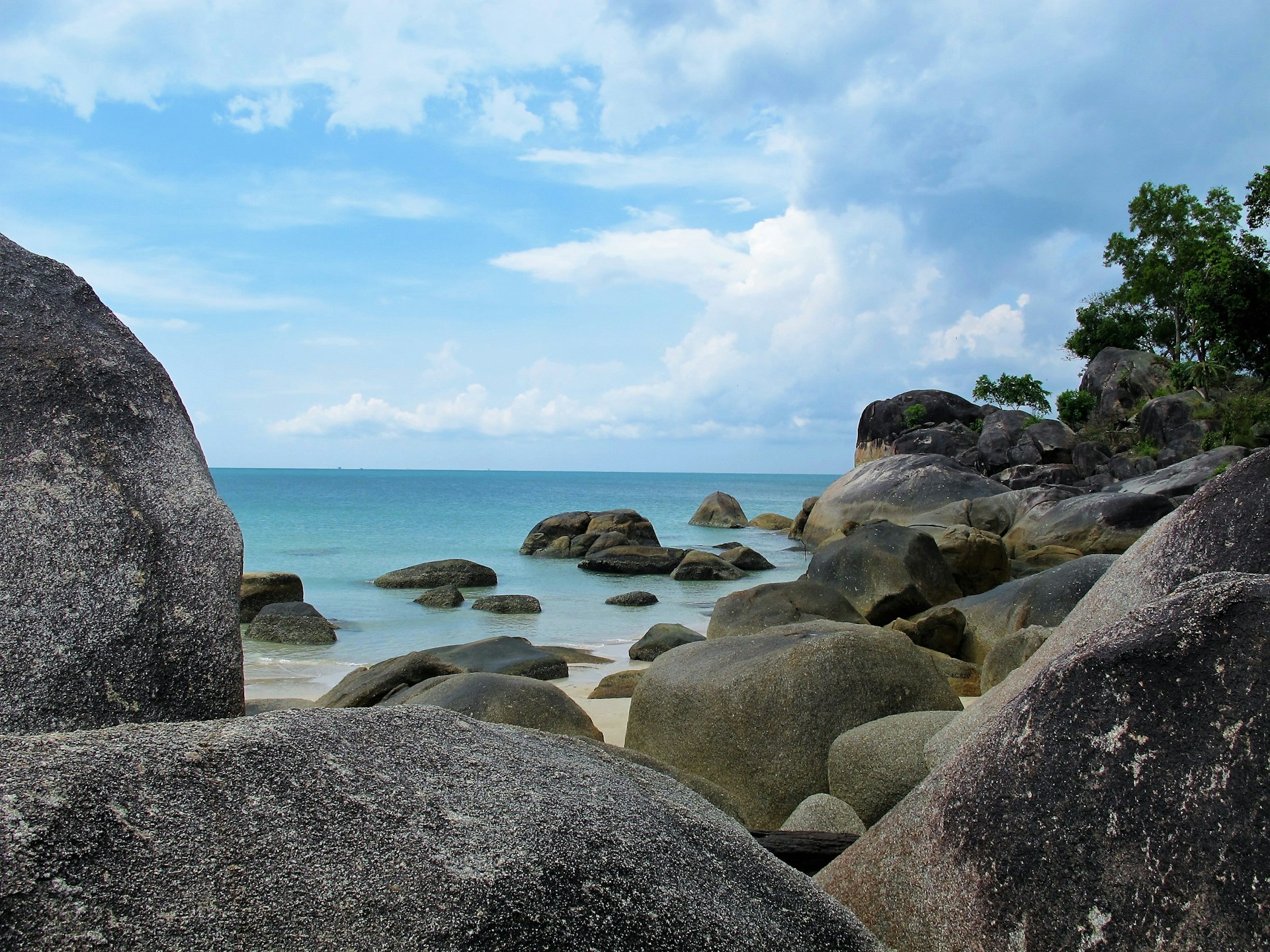 a beach with large rocks and a body of water