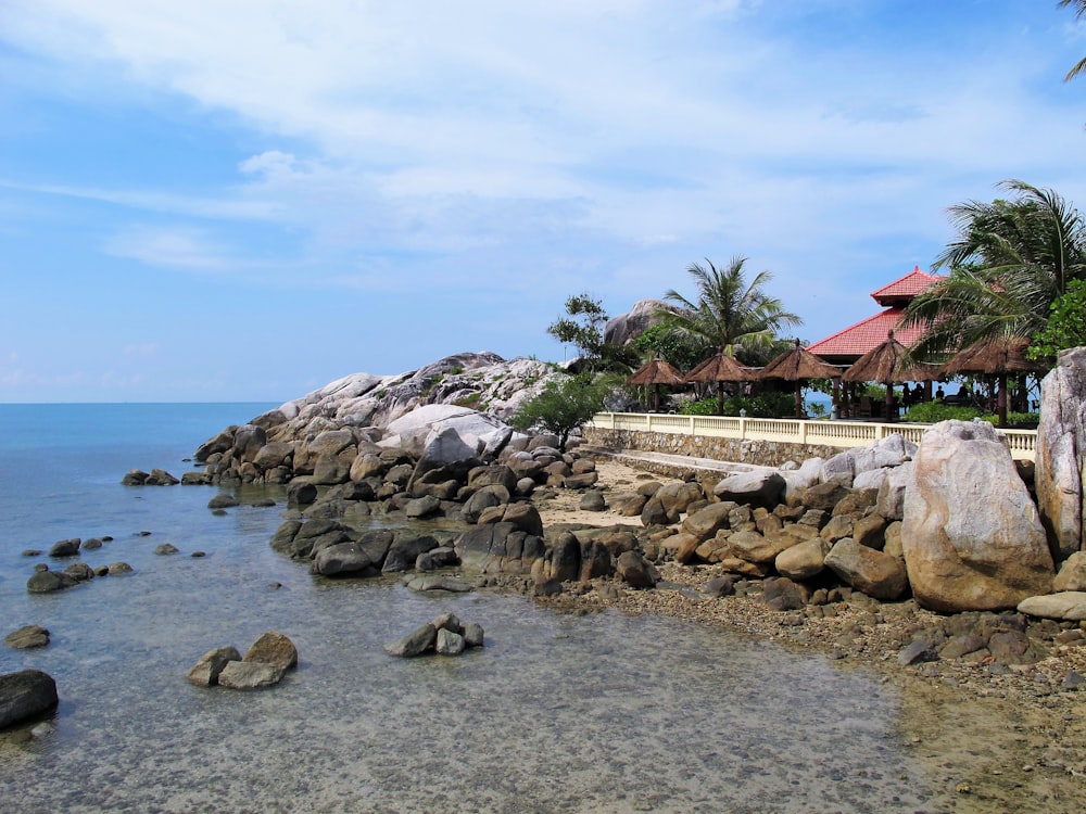 a view of a beach with rocks and a gazebo