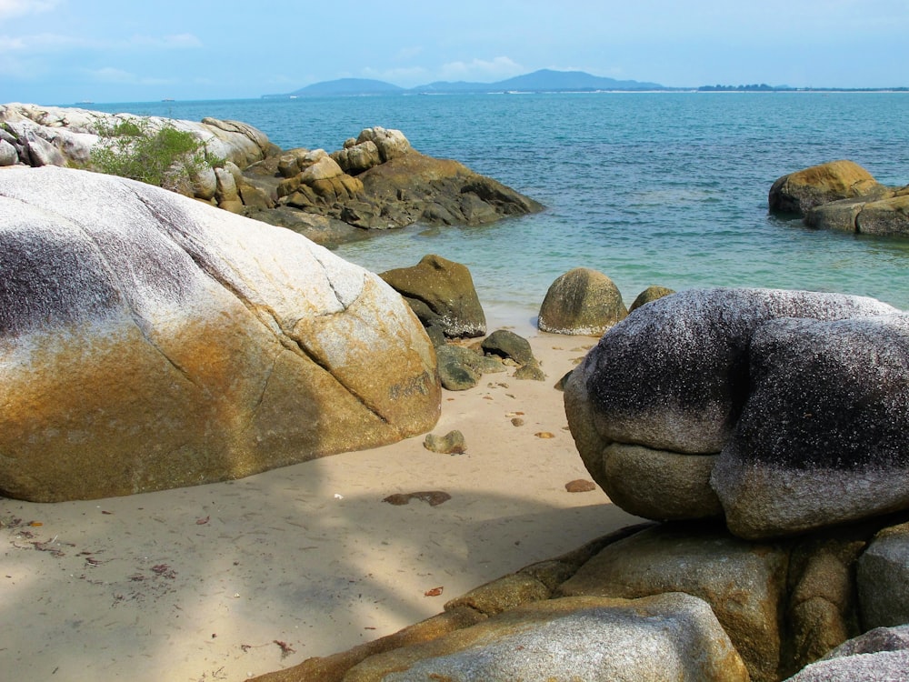 a large rock sitting on top of a sandy beach