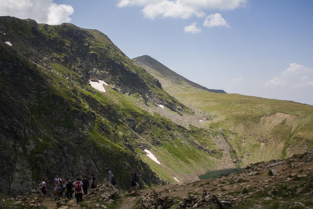 a group of people walking up the side of a mountain