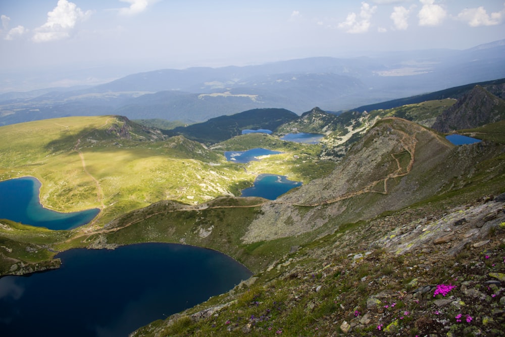 a view of a mountain with a lake and mountains in the background