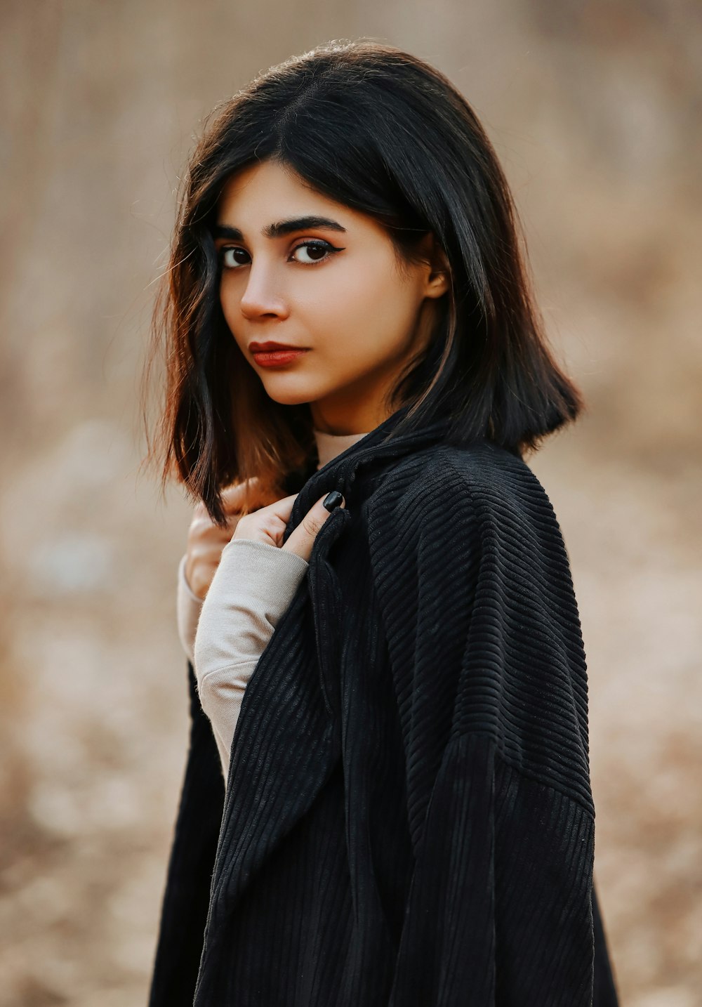 a woman in a black jacket is posing for a picture