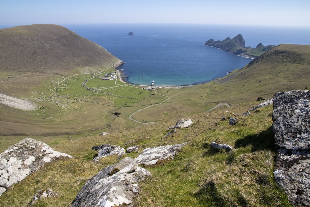 a view of a grassy area with a body of water in the distance