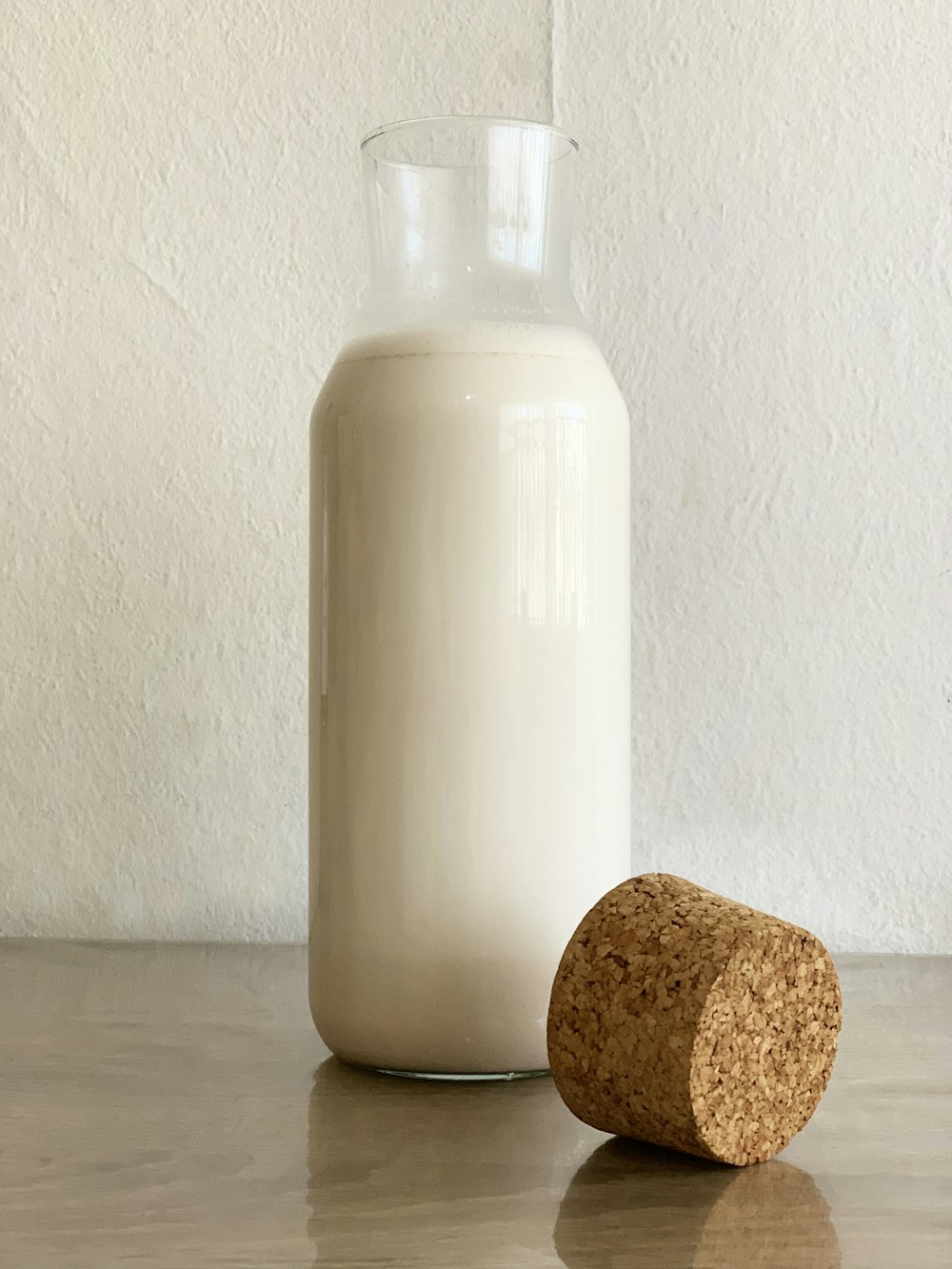 a bottle of milk and a cork on a table