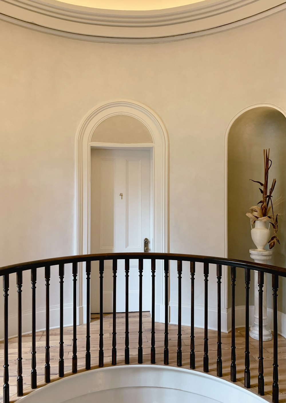 a spiral staircase in a home with a vase on the top of it