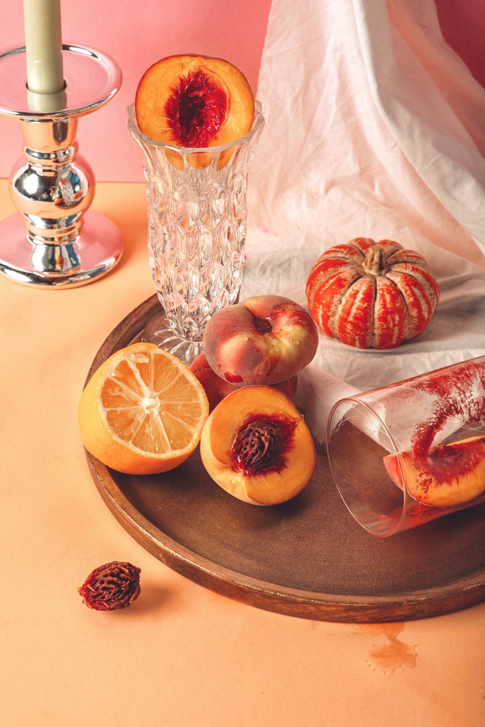 a wooden plate topped with sliced peaches and oranges