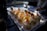 A tray of beautifully arranged desserts featuring small, round cakes topped with vibrant orange slices and garnishes, possibly mint. The cakes are neatly organized and displayed on a white rectangular plate, with soft lighting creating a warm, inviting atmosphere.