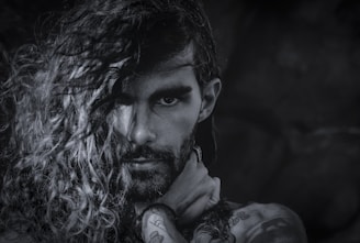 A minimalist black and white portrait of Guadalupe Carlota, tattoo artist, conveying a calm and focused expression.