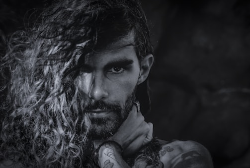 A sensual black-and-white portrait of Lola, capturing her confident gaze and artistic tattoos.