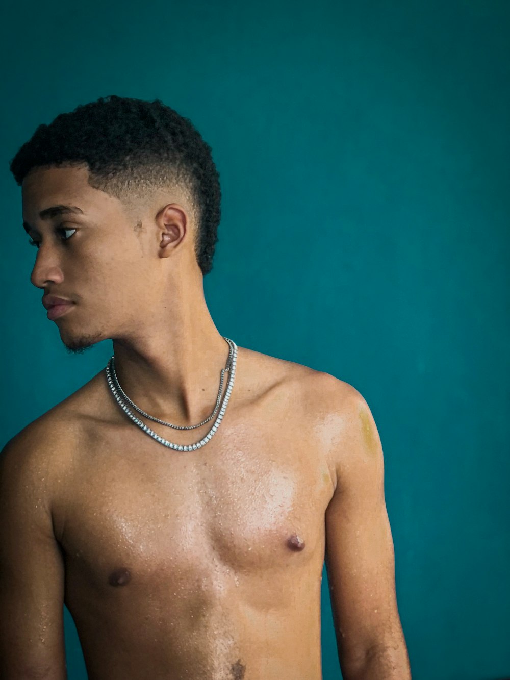 a shirtless man with a necklace around his neck