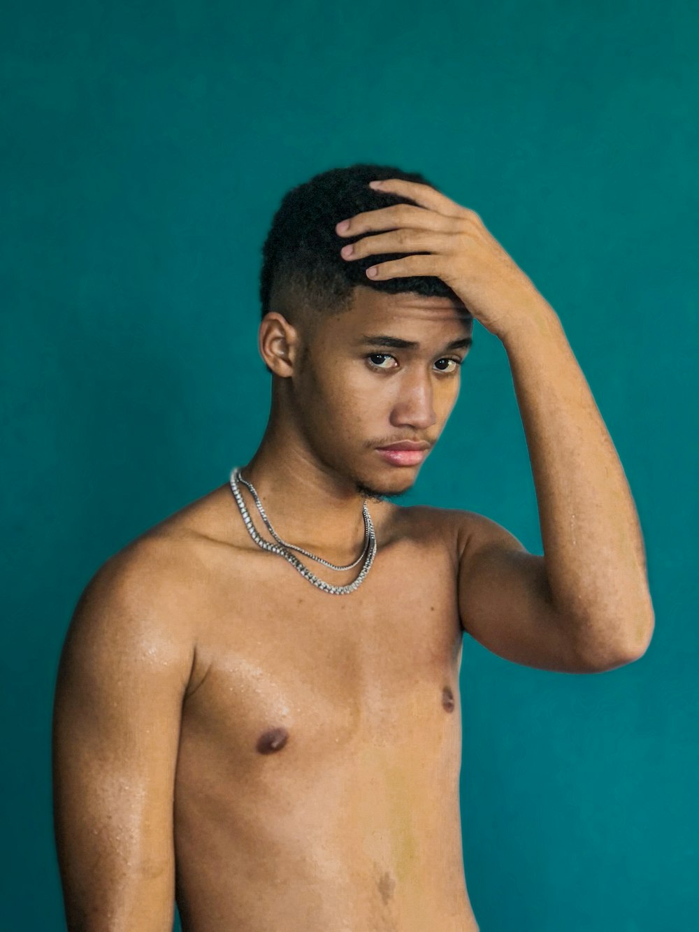 a shirtless man with a chain around his neck
