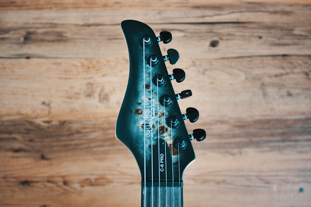 a close up of a guitar neck on a wooden background