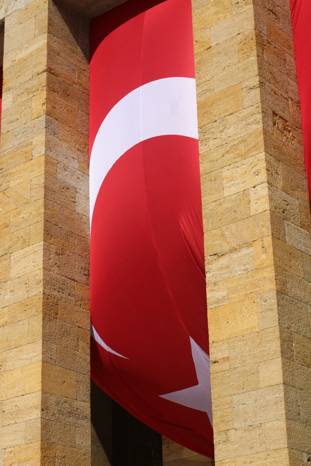 a large red and white flag hanging from the side of a building