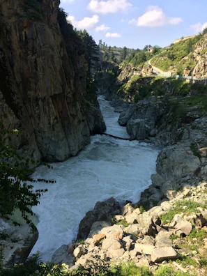 The river winding through a narrow gorge with ancient stone carvings visible on the riverbank.