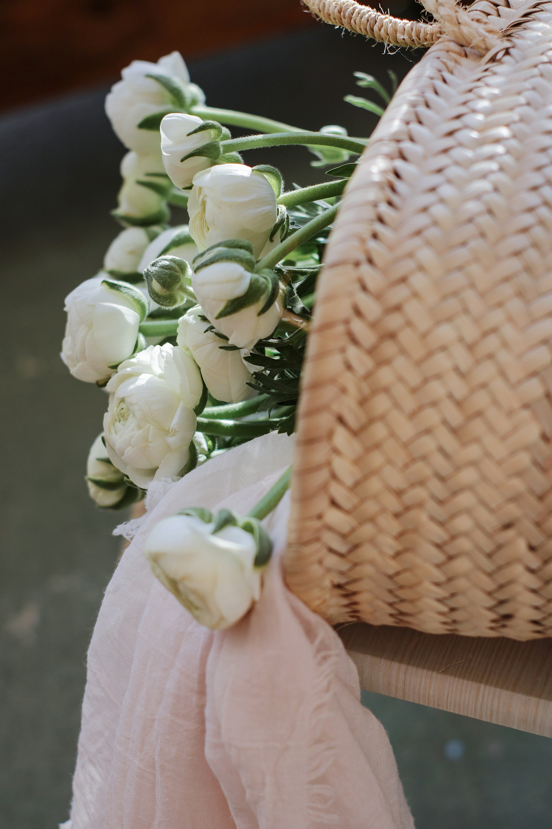 a bouquet of white flowers sitting on top of a wooden bench