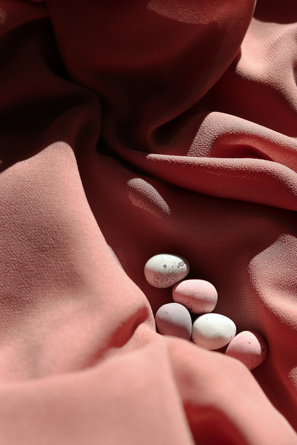 a close up of two pills on a pink cloth